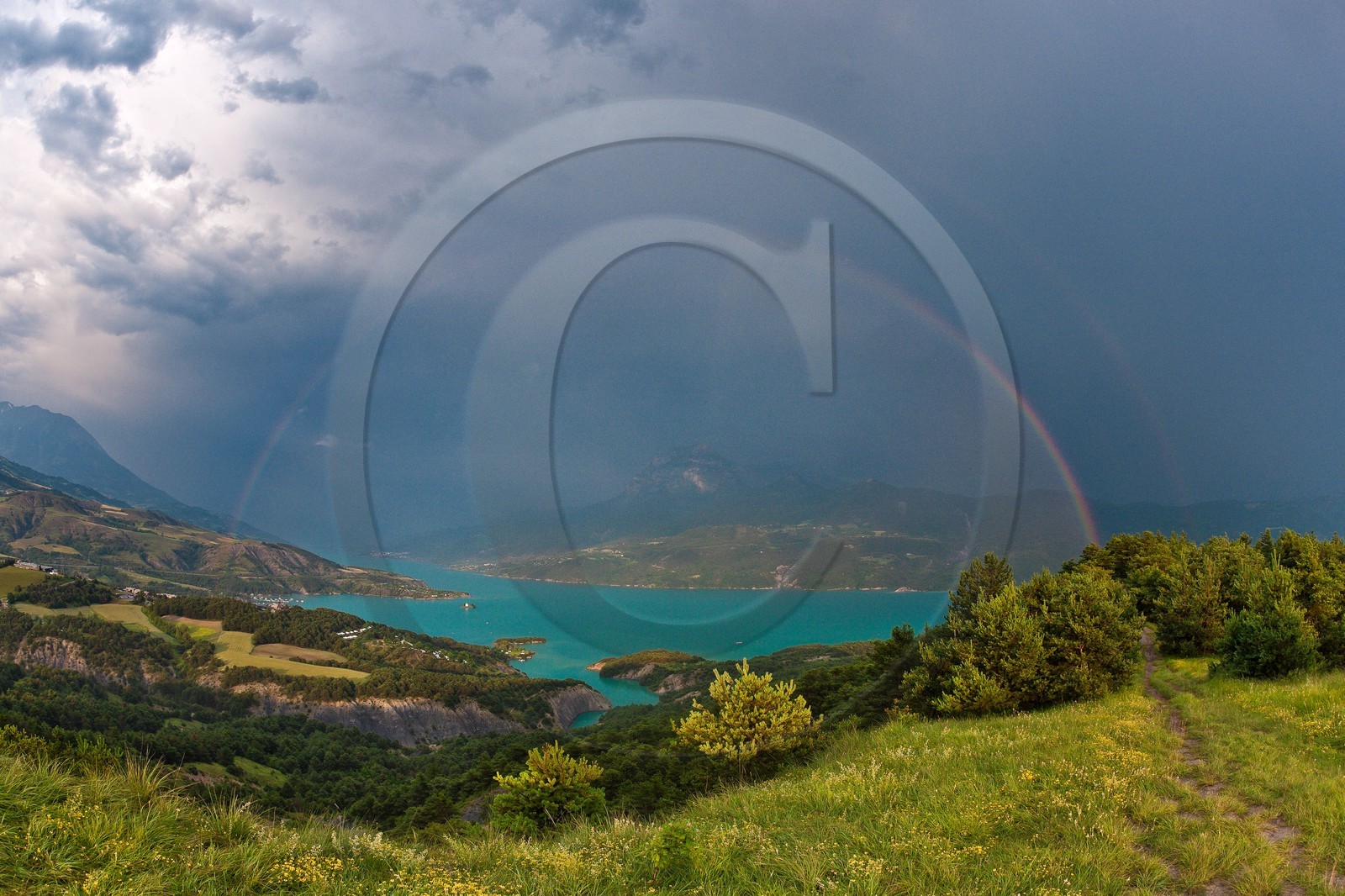 Lac de Serre-Ponçon, la baie et la Chapelle Saint-Michel, le Pic de Morgon et l'arc-en-ciel